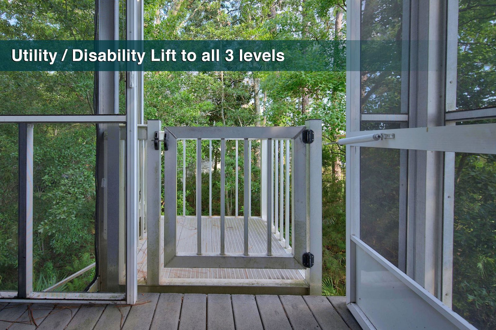 A utility lift platform behind a hinged rail gate, seen through an open screen door, with trees beyond. A text band across the top reads "Utility / Disability Lift to all 3 levels."